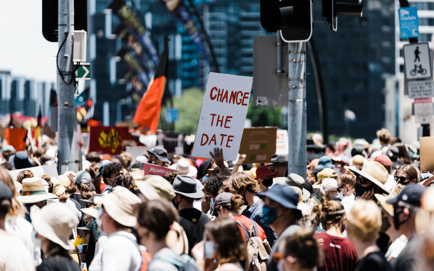 A group of people holding placards protest on a busy city street.