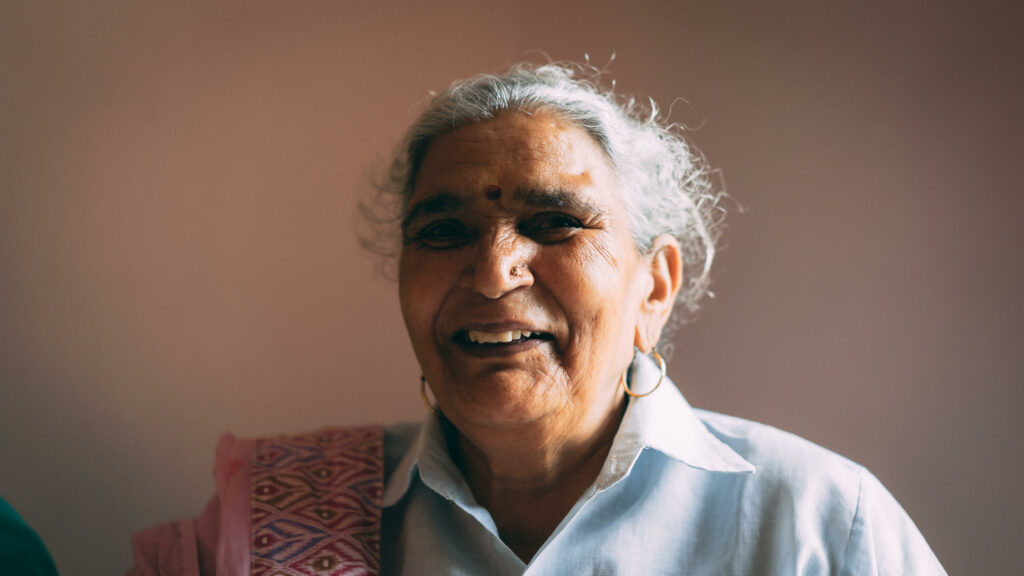 A portrait of an elderly, smiling woman.