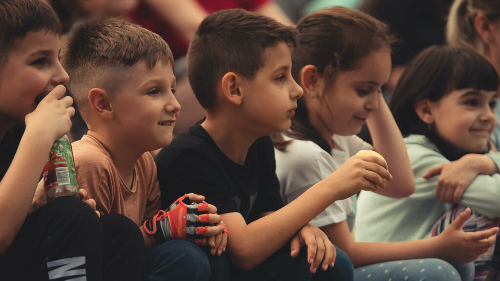 Photograph of children sitting in a row.