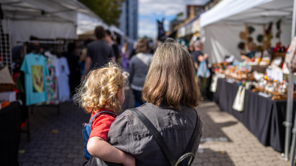 Survey of separated parents - mother and child at a market.